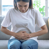 A woman holding her belly in pain