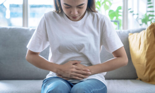 A woman holding her belly in pain