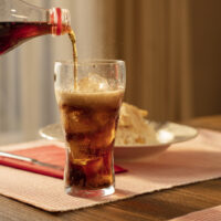 Someone pouring a glass of Diet Coke