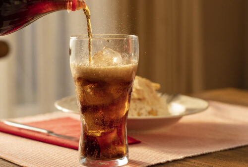 Someone pouring a glass of Diet Coke