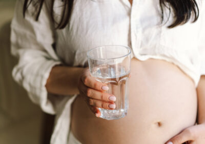 a pregnant woman with a glass of drinking water