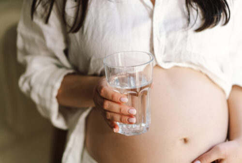 a pregnant woman with a glass of drinking water