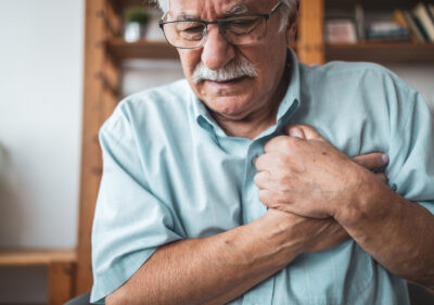 Close up photo of a man feeling a sharp pain in his chest