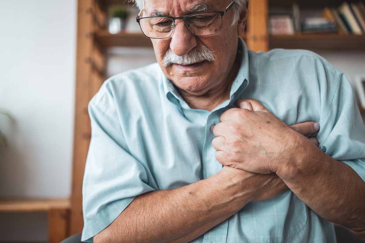 Close up photo of a man feeling a sharp pain in his chest