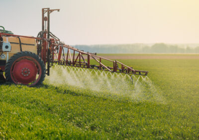 A tractor sprays herbicides on a field