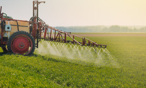 A tractor sprays herbicides on a field