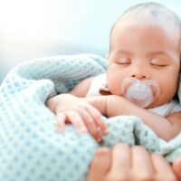 A baby sucking on a pacifier