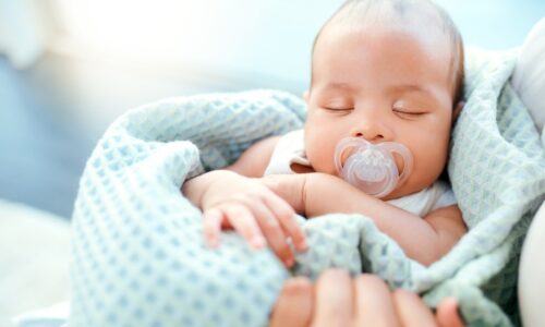A baby sucking on a pacifier