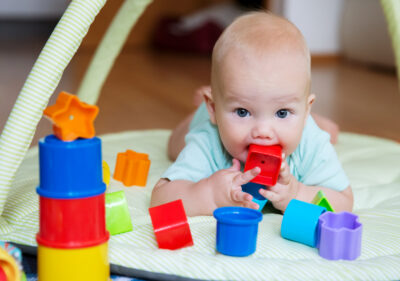 A baby with a plastic toy in their mouth