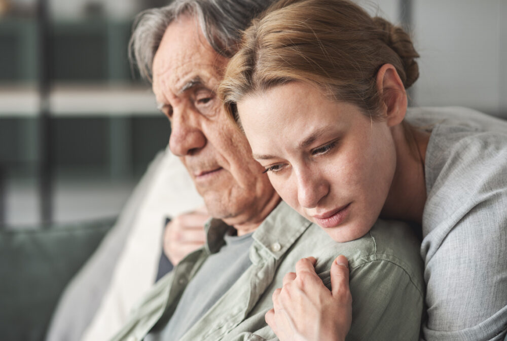 A sad woman hugging her sad father