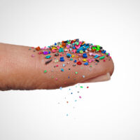 colorful microplastics on someone's finger