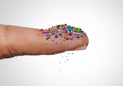colorful microplastics on someone's finger