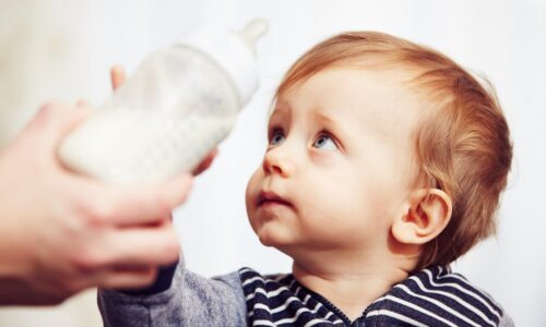 Baby with a plastic bottle