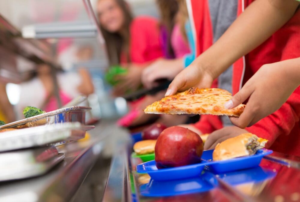 School lunch tray with ultra-proceessed food and an apple
