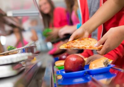 School lunch tray with ultra-proceessed food and an apple